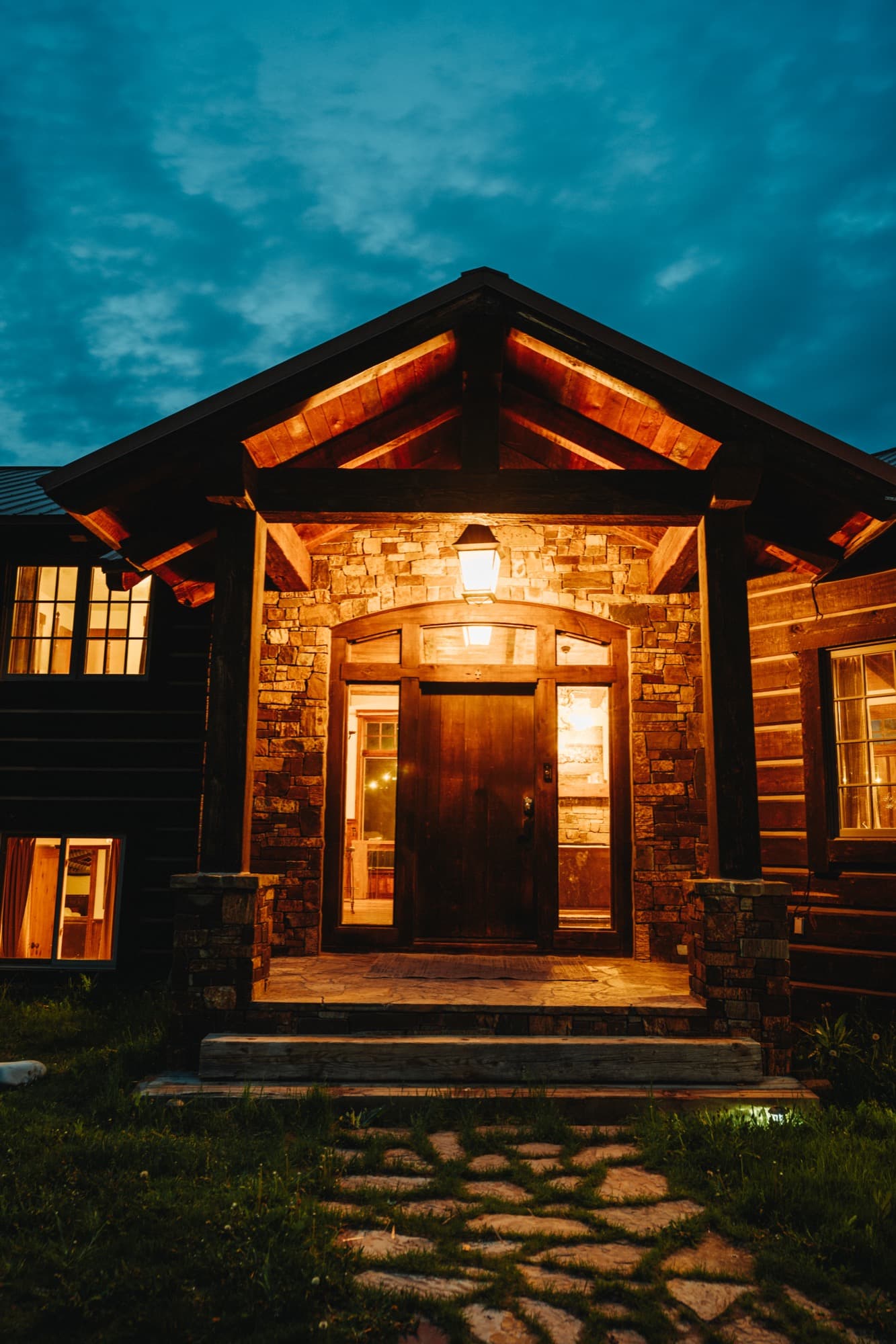 Timber-framed cabin entrance lit warmly at night