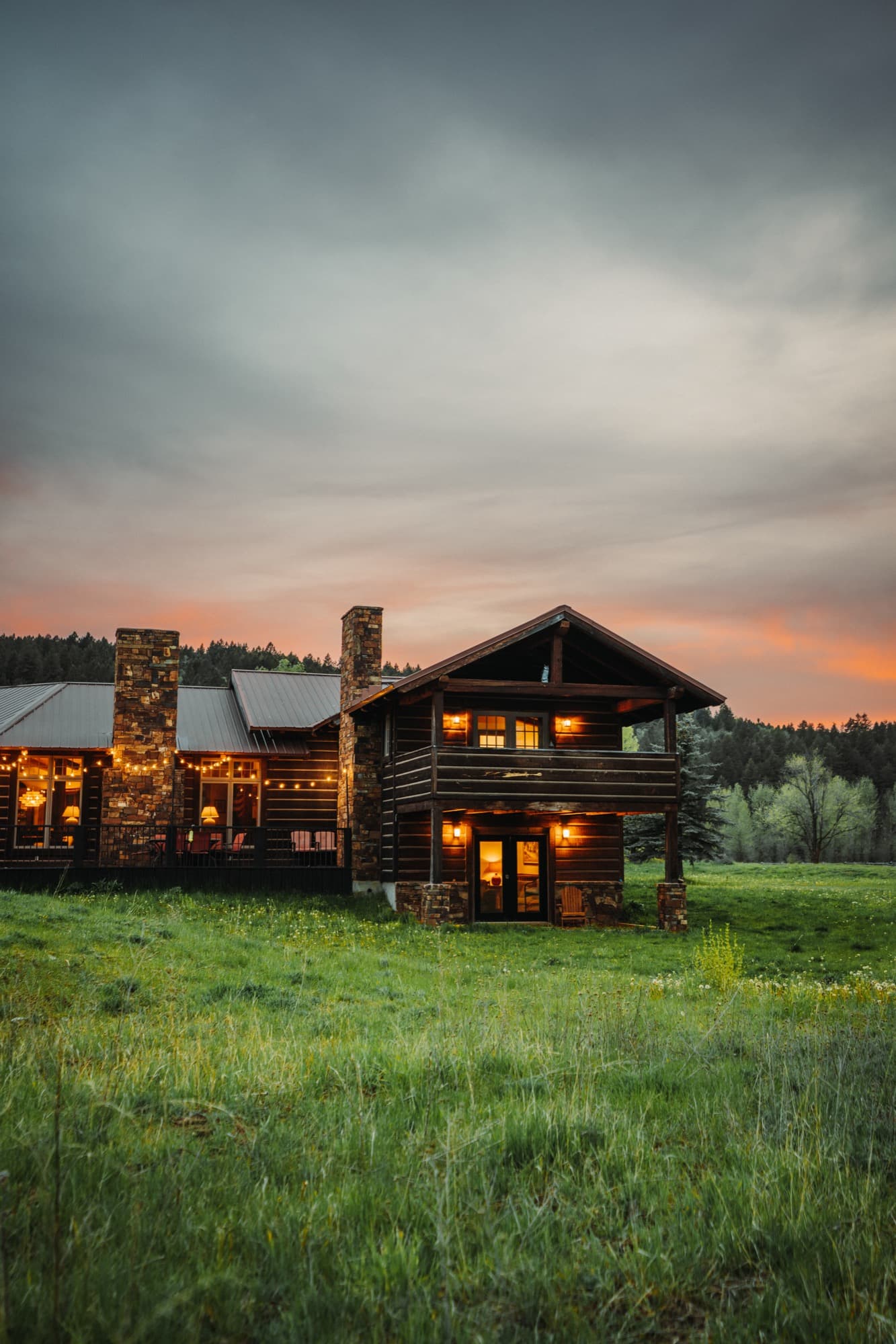 Log cabin at sunset surrounded by open meadow